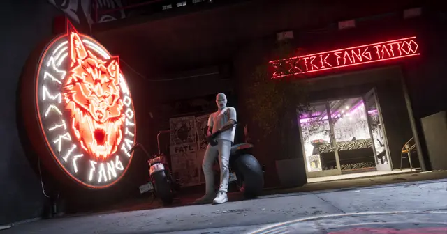 A neon tattoo parlour sign at night with a rider outside